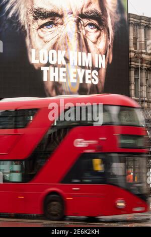 Ein roter Londoner Bus fährt während der dritten nationalen Sperre Englands unter einer Werbung mit dem Coronavirus der Regierung auf der Großleinwand des Piccadilly Circus, London, um die Ausbreitung des Coronavirus einzudämmen. Bilddatum: Freitag, 29. Januar 2021. Stockfoto