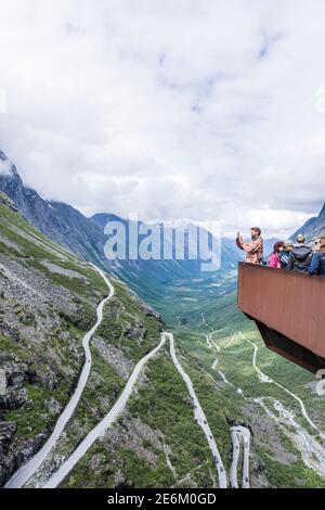 Touristen stehen auf dem Trolls Path Aussichtspunkt mit Blick auf die schöne Tal mit Trollstigen Pass in Norwegen Stockfoto