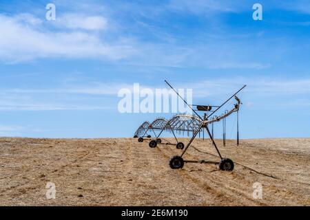 Bewegliches Bewässerungssystem auf einem trockenen Stoppelfeld in Alentejo, Portugal Stockfoto