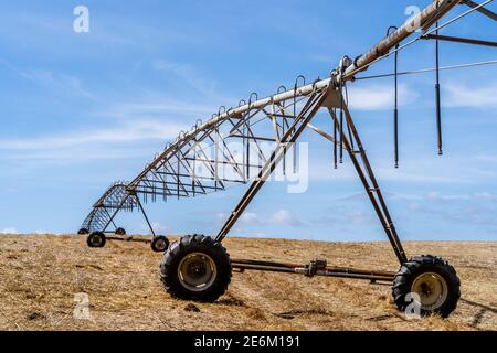 Bewegliches Bewässerungssystem auf einem trockenen Stoppelfeld in Alentejo, Portugal Stockfoto