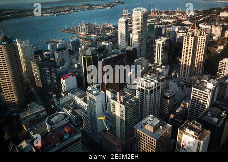 Panorama-Weitwinkelansicht eines Mannes, der an einem sonnigen Tag vom Sky Tower Observatory über Downtown springt, Auckland, Nordinsel, Neuseeland Stockfoto