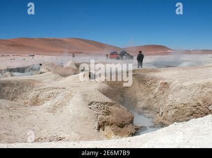 Touristen auf einer Jeep-Tour während einer Rast im Geysirfeld «Sol de Manana» am 15. Oktober 2009. Das Geysir-Feld, das in der Anden Altiplano zwischen der chilenischen Stadt San Pedro de Atacama und Uyuni in Bolivien liegt, ist ein Geothermie-Gebiet auf 4850 Metern. Foto: Hauke Schroder weltweit im Einsatz Stockfoto