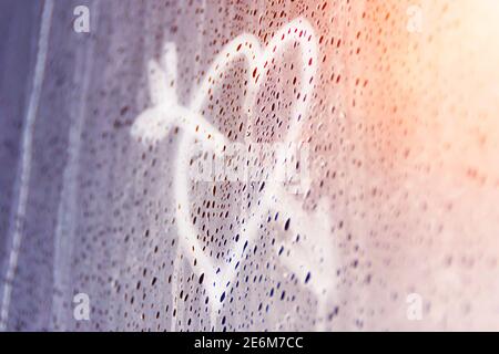 Herz durchbohrt von einem Pfeil auf Nebelglas gemalt, ein Symbol für Gefühle der Liebe und Beziehungen. Die erste Liebe Stockfoto