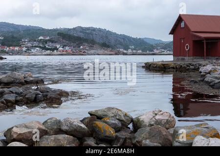 Rotes Bootshaus auf einer kleinen Halbinsel bei Sonnenuntergang an der Küste von Lindesnes, Norwegen Stockfoto