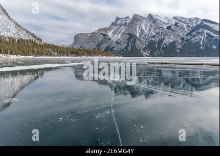 Reflexionen im gefrorenen Lake Minnewanka im Banff National Park, Alberta, Kanada Stockfoto