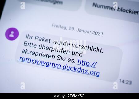 Berlin, Berlin, Deutschland. Januar 2021. Auf dem Display eines Smartphones ist eine SMS mit einer potentiell gefährlichen Nachricht zu sehen. Die gefälschte SMS zirkulierte landesweit und enthielt eine Anfrage, ''Ihr Paket wurde gesendet, bitte überprüfen Sie es.'' und einen Link mit der Endung 'uckdns.org''. Laut Polizei nutzen die Täter offenbar die Situation der Corona-Pandemie, in der viele Menschen Waren im Internet bestellen. Im schlimmsten Fall würde die Malware auf das Telefon geladen, weitere SMS gesendet und empfangen und möglicherweise die Fernsteuerung des Smartphs ermöglichen Stockfoto