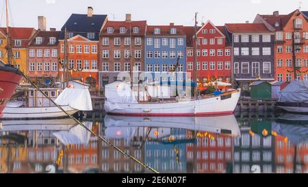 Bunte frühmorgendliche Reflexion an der Uferpromenade des Nyhavn-Kanals (Neuer Hafen), einem Unterhaltungs- und Touristenviertel von Kopenhagen, Dänemark. Stockfoto