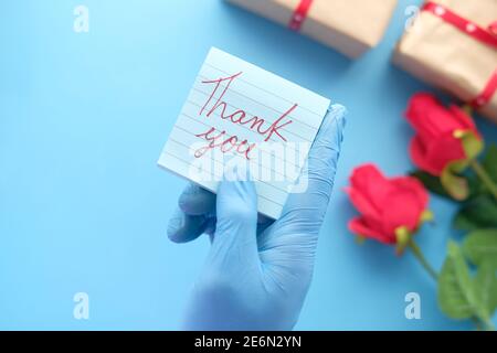 Person Hand in Latexhandschuhe halten Dankschreiben Stockfoto