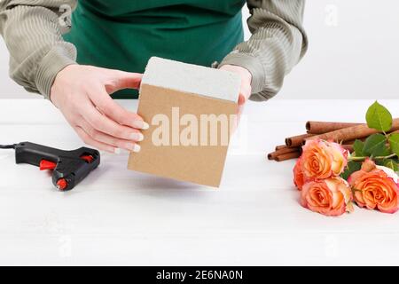 Florist bei der Arbeit: Wie man Blumenarrangement mit Rosen und Zimtstangen machen. Schritt für Schritt, Tutorial. Stockfoto