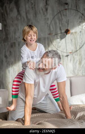 Das Kind sitzt mit dem Rücken auf dem Bett Stockfoto