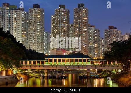 Brücke über den Lam Tsuen Fluss in Tai Po mit hohen Wohnhäusern. New Territories, Hongkong Stockfoto