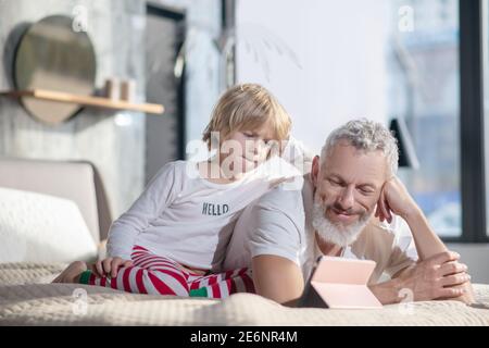Vater und Kind beobachten Tablet zusammen zu Hause Stockfoto