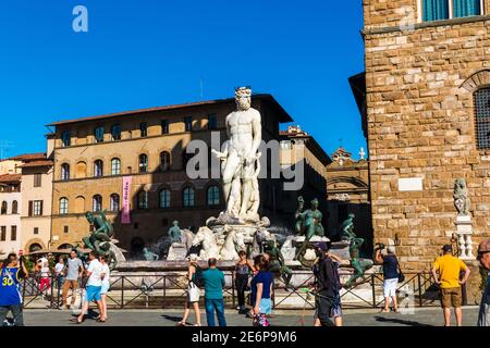 Schöner Blick auf die Menschen, die den beliebten Skulpturenbrunnen Neptun auf der Piazza della Signoria neben dem Palazzo bewundern und fotografieren... Stockfoto