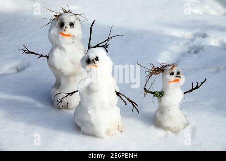 Winter-Frühling Geschichte der Schneemann Familie Schneemann-Vater, Schneemann-Mutter, Schneemann-Kind im Schnee Stockfoto