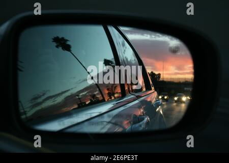 Sonnenuntergang in Los Angeles vom Seitenspiegel von gesehen Ein Auto, das die Straße entlang fährt Stockfoto