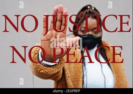 Keine Gerechtigkeit, kein Frieden. afroamerikanische Frau, tragen schwarze Gesichtsmaske zeigen Stop Hand Zeichen. Stockfoto