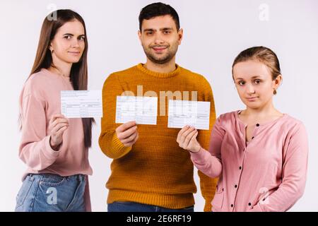 Junge Menschen mit Karten über die Impfung gegen das Covid-19-Virus. Weißer Hintergrund. Stockfoto