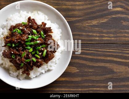 Nahaufnahme der koreanischen Hackfleisch und Reis Schüssel auf Holz Hintergrund mit freien Text Raum. Draufsicht, flach liegend Stockfoto