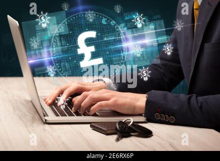 Business Hand arbeiten an der Börse mit Pfund-Symbole kommen Aus dem Laptop-Bildschirm Stockfoto