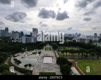 Luftaufnahme des West Irian Liberation Monument in der Innenstadt von Jakarta und Lärmwolke mit Jakarta Stadtbild. JAKARTA - Indonesien. Januar 30, 2021 Stockfoto