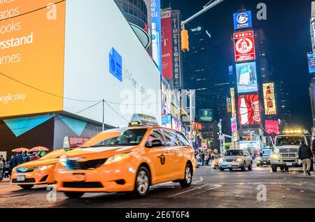 Speeding Taxi in New York City Times Square. Große animierte LED-Bildschirme und Toshiba-Turm im Hintergrund. Manhattan, New York City, USA Stockfoto