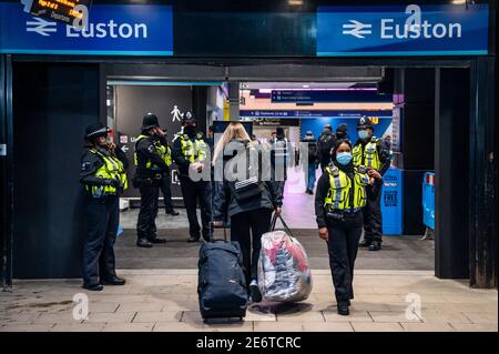 London, Großbritannien. Januar 2021. Die britische Verkehrspolizei überprüft vor Ort die Reiseziele der Reisenden, da die Euston Station trotz der neuen nationalen Lockdown, Stay at Home, Anweisungen immer noch recht voll ist. Sie sagten, dass sie eine Person mit einer Geldstrafe belegt hätten, aber der Check ist ziemlich sanft, da sie sich auf die Ehrlichkeit der Passagiere verlassen. Die meisten Reisenden tragen Masken, da sie bereits obligatorisch sind. Kredit: Guy Bell/Alamy Live Nachrichten Stockfoto