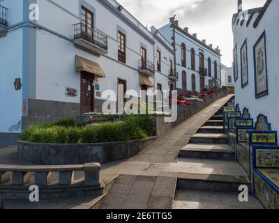 Firgas, Gran Canaria, Kanarische Inseln, Spanien 13. Dezember 2020: Blick auf die Straße Paseo de Gran Canaria mit Wasserfall Brunnen, Blumen und Keramik Stockfoto