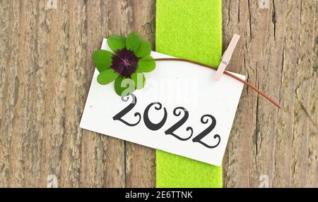 Neujahrskarte für das Jahr 2022 mit Kleeblatt Auf Holzhintergrund Stockfoto