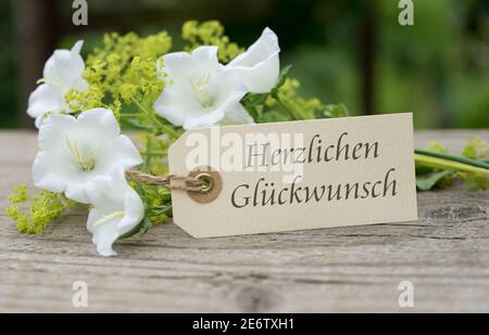Grußkarte mit weißen Glockenblumen und deutschem Text herzlichen Glückwunsch Stockfoto