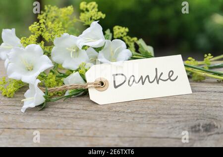 Grußkarte mit weißen Glockenblumen und deutschem Text dank Stockfoto