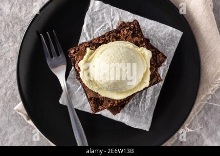 Brownie mit Vanilleeis Schaufel auf grauem Stein Hintergrund Stockfoto