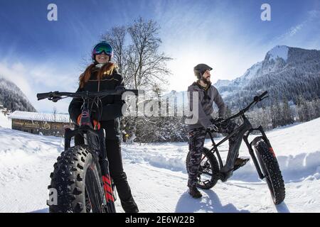 Frankreich, Haute Savoie (74) Massif du Chablais, Val d'Abondance, Les Portes du Soleil, La Chapelle d'Abondance , elektrisches Fatbike auf der Piste, 1 junge Paare, die eine Pause vor der Sonne machen Stockfoto