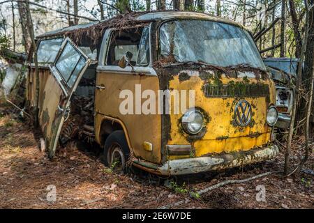 Ein leuchtend gelber gebrochener und rostiger volkswagon Bus oder Van In den Wäldern verlassen, um Verfall vergessen und verlassen Stockfoto