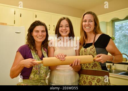 Drei attraktive Erwachsene kaukasischen Frauen Hause Bäcker halten Nudelholz in der Küche, Wisconsin, USA Stockfoto