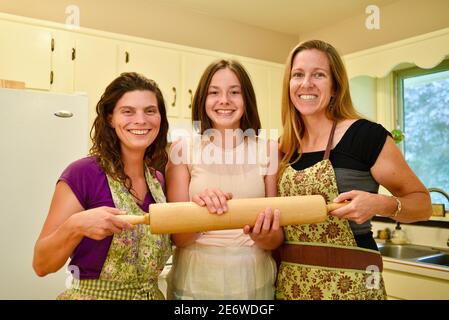 Drei attraktive Erwachsene kaukasischen Frauen Hause Bäcker halten Nudelholz in der Küche, Wisconsin, USA Stockfoto