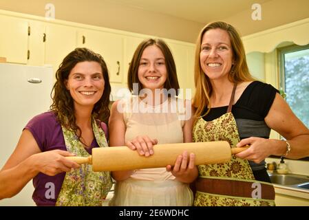 Drei attraktive Erwachsene kaukasischen Frauen Hause Bäcker halten Nudelholz in der Küche, Wisconsin, USA Stockfoto
