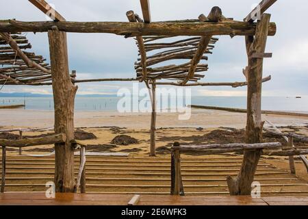 Winter auf einem beliebten jeder in der Nähe Grado, Friaul-Julisch Venetien, Nordostitalien. Eine provisorische Strandbar wurde bis zum Beginn der Sommersaison abgebaut Stockfoto