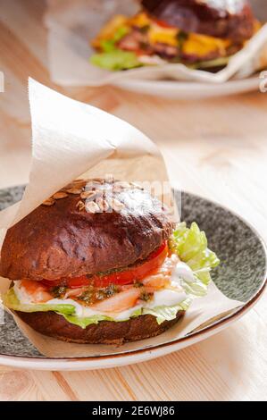 Rauch Lachsburger auf dem Teller im Restaurant Stockfoto