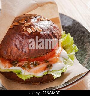 Geräucherter Lachsburger auf dem Teller im Restaurant Stockfoto