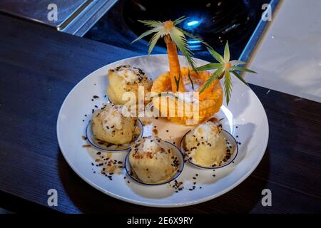 Mehrere Stücke von Dessert, in einem Teller dekoriert, auf der Seite Set Dekoration mit zwei Palmen Stockfoto