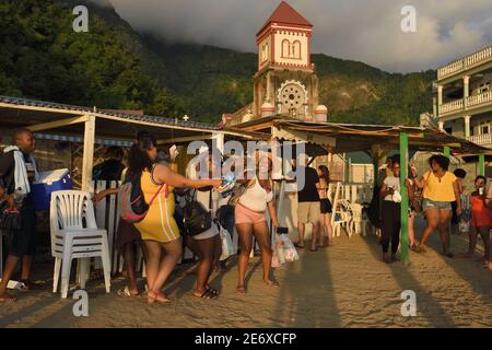 Karibik, Dominica Island, Soufri Bay, das Dorf Soufri're, Rum-Bar am Strand und die katholische Kirche Saint Mark im Hintergrund Stockfoto