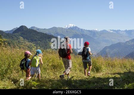 Frankreich, Savoie, Massiv der Vanoise, die 3 Täler, Saint Martin de Belleville, Pere und seine drei Kinder auf einem Spaziergang über Saint Jean de Belleville und mit Blick auf den Mont Blanc Stockfoto