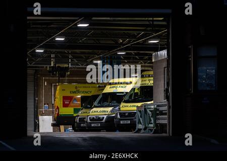 NHS Ambulance Station mit Flotte von sauberen Krankenwagen geparkt warten Für Notfallmaßnahmen bei Unfällen und Notfällen während einer Pandemie Blau Stockfoto