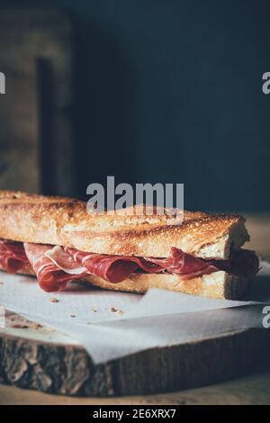 Vertikale Aufnahme eines mit jamón ibérico gefüllten Brotbaguettes Oder iberischer Schinken Stockfoto