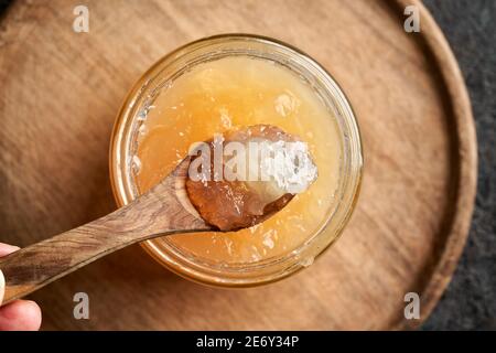 Gekühlte geriebene Rinderknochenbrühe auf einem Holzlöffel oben Ein Glas Stockfoto