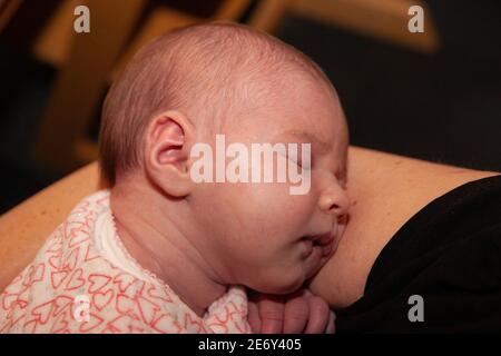 Neugeborenes Mädchen, das in den Armen ihrer Mutter schläft. Stockfoto
