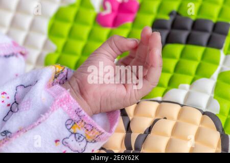 Liebenswert niedlichen Baby Mädchen Handfläche der linken Hand und Finger Nahaufnahme Makrofotografie, drei Wochen alt Kleinkind. In schönen rosa Kleidung und Slee gekleidet Stockfoto