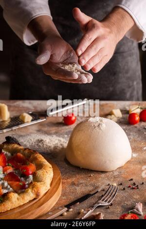 Koch bereitet Pizzateig zu Hause oder in der Küche zu. Stockfoto