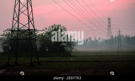 Ländliche Dorf am frühen Morgen Nebel und malerischen roten Himmel Wolken Landschaft Foto. Nicht so gerade hölzerne elektrische Pole in das Reisfeld, fährt Stockfoto