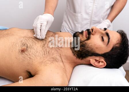 Stock Foto von unerkannten Arbeiter, die ein Verfahren mit Baumwolle zu männlichen Kunden. Stockfoto